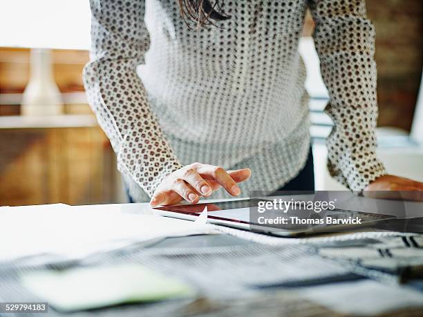 businesswoman looking at digital tablet in office - interface dots stock-fotos und bilder