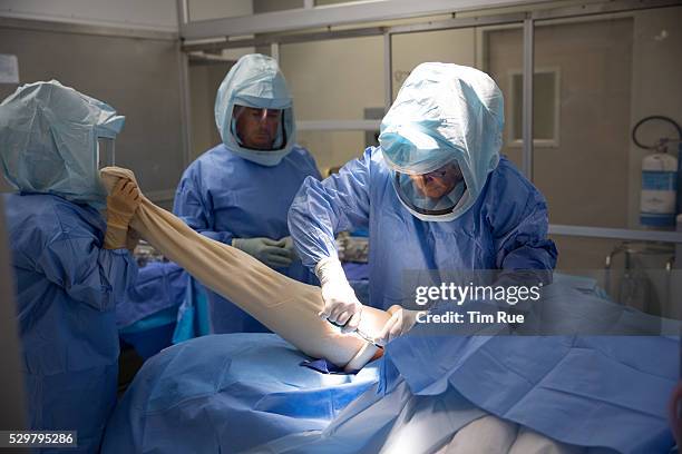 Surgeon performs hip replacement surgery.