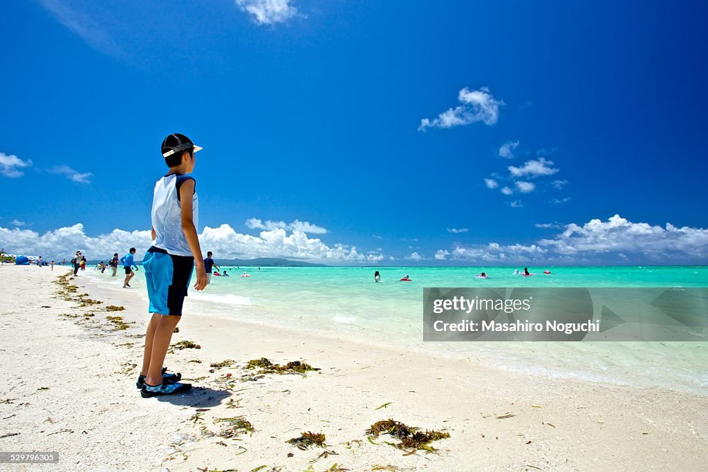 A boy standing by the sea