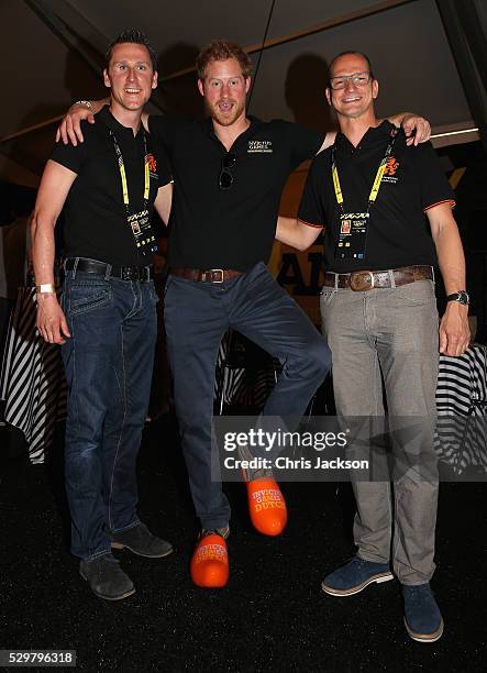 Prince Harry is presented with some orange cloggs by the Dutch Team Captain Rahmon Zondervan during a reception for the Invictus Games Foundation at...