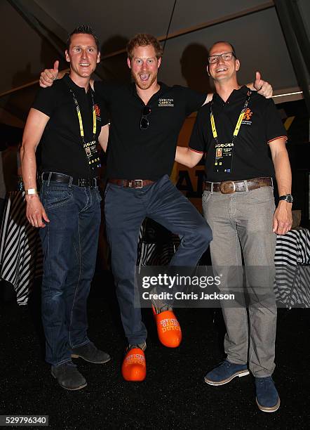 Prince Harry is presented with some orange cloggs by the Dutch Team Captain Rahmon Zondervan during a reception for the Invictus Games Foundation at...
