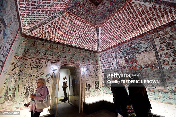 People visit the "Cave Temples of Dunhuang: Buddhist Art on the Silk Road" exhibit at the Getty Center in Los Angeles on May 9 viewing a full-scale,...