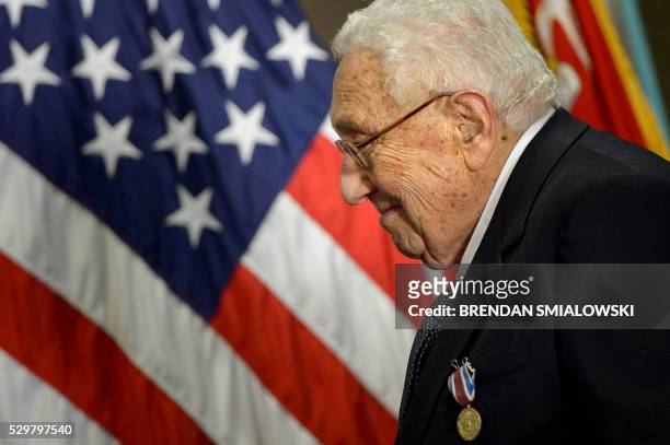 Former US Secretary of State Henry Kissinger smiles after receiving an award during a ceremony at the Pentagon honoring his diplomatic career May 9,...