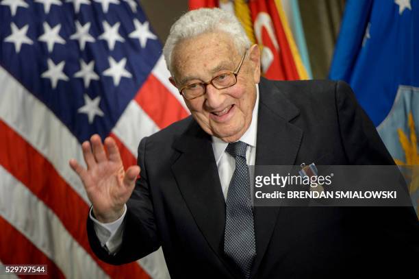 Former US Secretary of State Henry Kissinger waves after receiving an award during a ceremony at the Pentagon honoring his diplomatic career May 9,...