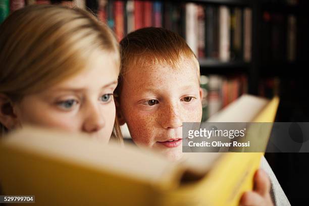 girl and boy (10-12) reading book - archival library stock pictures, royalty-free photos & images