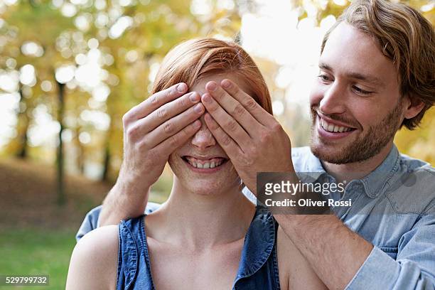 young couple in park - augen zuhalten stock-fotos und bilder