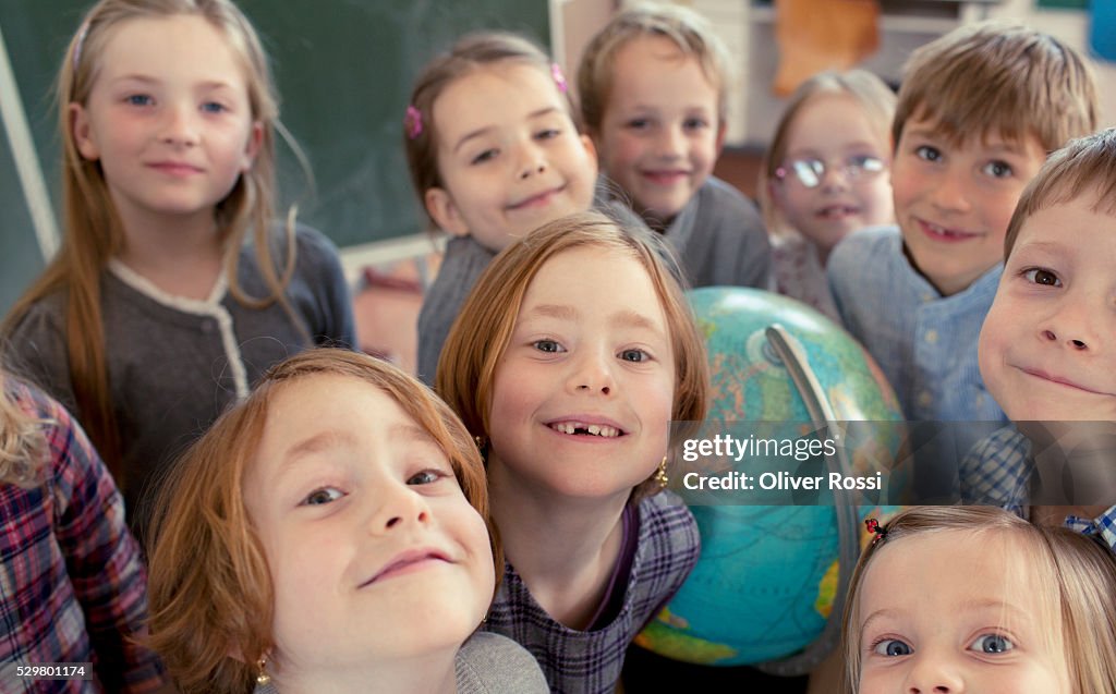 Group of schoolchildren (8-9) standing in classroom