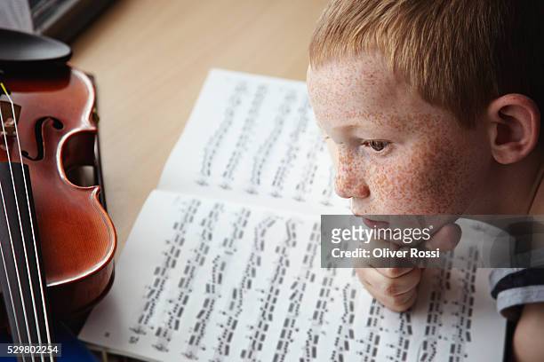 redheaded boy with violin and sheets of music - boy freckle stock pictures, royalty-free photos & images