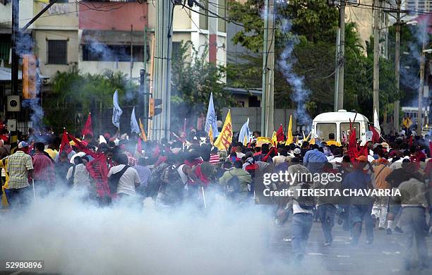 Manifestantes tratan de evitar gases lacrimogenos lanzados por la policia en la Avenida 5 de Mayo de la Ciudad de Panama el 25 de mayo de 2005....