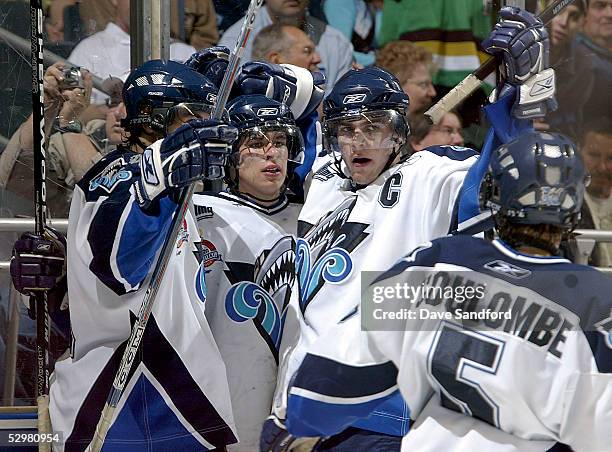 Sidney Crosby of the Rimouski Oceanic celebrates with teammates Marc-Antoine Pouliot and Patrick Coulombe after scoring on the Kelowna Rockets during...