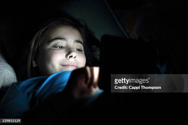 happy child in the dark with tablet - stupid girls stock pictures, royalty-free photos & images