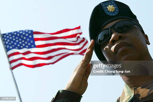 Soldier salutes as United Nations Command Honour Guards carry coffins which contain the remains of soldiers who fought in the 1950-53 Korean War...