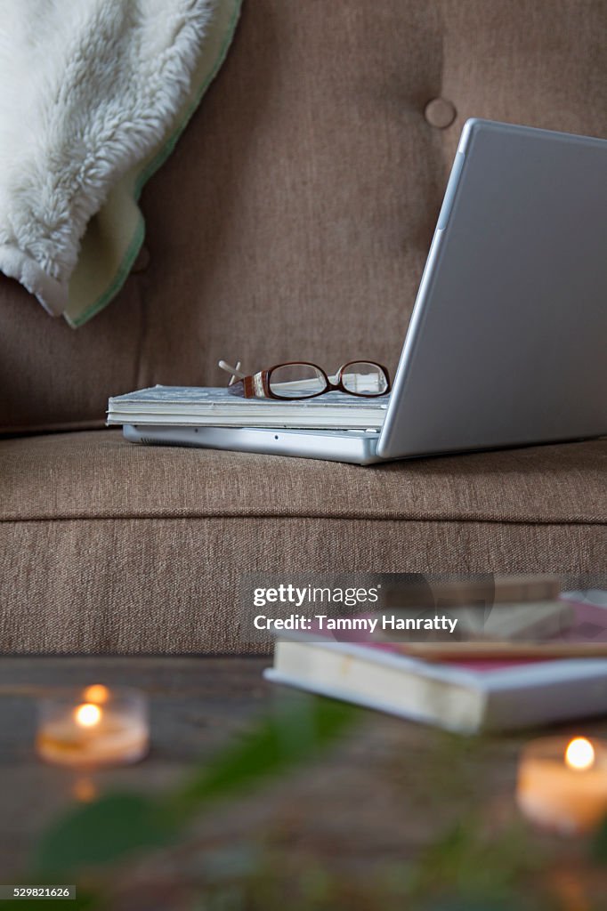 Close up of glasses and laptop on sofa