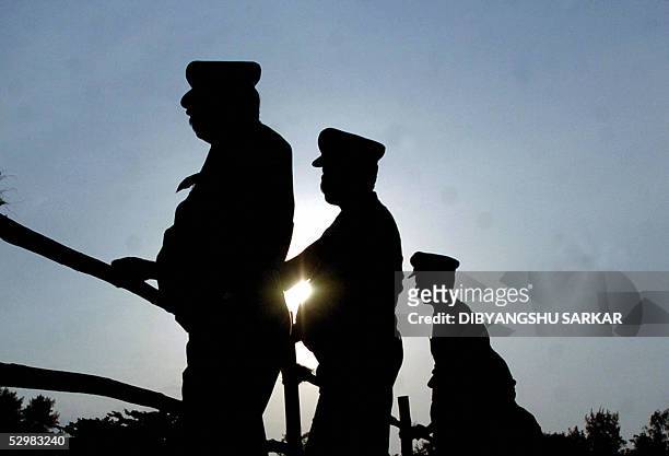 Indian police officers stand guard at a camp for displaced people in the coastal city of Nagapattinam some 325 kms south of the southern Indian city...