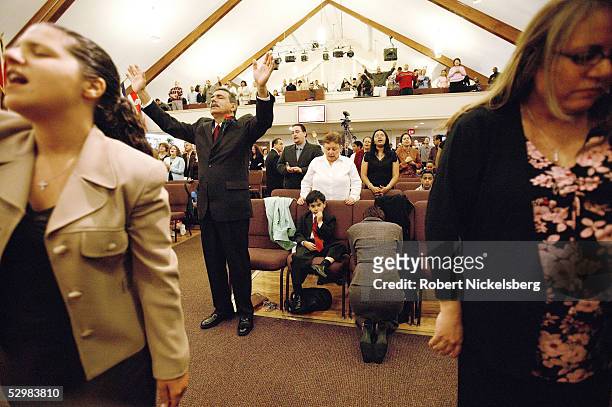 Joe Martinez prays with Josiah, his 5-year-old son, during a two-hour English Sunday service at a Christian Pentecostal evangelical church in the Bay...