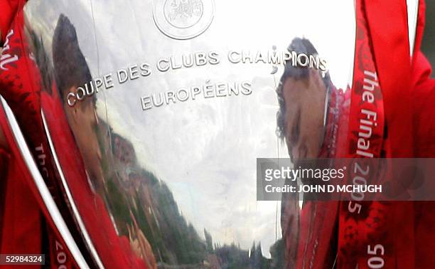 Liverpool players are reflected in the Champion's League trophy as the hold it aloft to the thousands of fans gathered to welcome them home, 26 May...