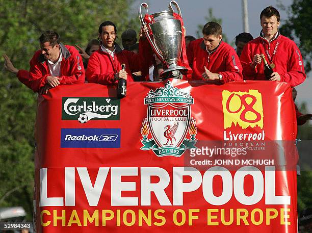 Liverpool players Jamie Carragher, Luis Garcia, Steven Gerrard and John Arne Riise hold up the Champion's League trophy to the thousands of fans...