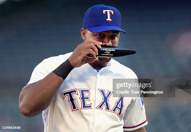 Adrian Beltre of the Texas Rangers smells a piece of a broken bat against the Chicago White Sox in the top of the first inning at Globe Life Park in...