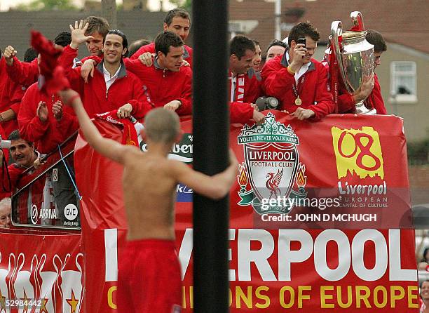 Young fan waves to the Liverpool team as they pass their home ground at the Kop end of Anfield during a parade to welcome home the team, 26 May...