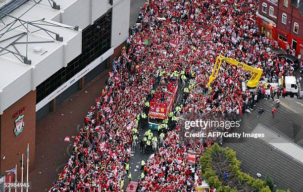 Thousands of fans cheer the Liverpool football team as they pass Anfield during a parade to welcome them home, 26 May following their Champions...