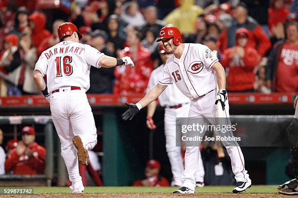 Tucker Barnhart of the Cincinnati Reds is congratulated by Jordan Pacheco after hitting a solo home run to break a tie game against the Pittsburgh...