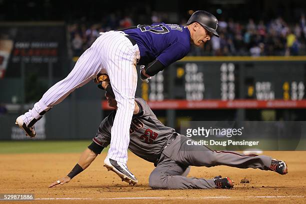 Trevor Story of the Colorado Rockies is tagged out by third baseman Jake Lamb of the Arizona Diamondbacks while trying to reach third on an RBI...