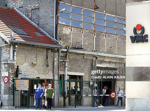 Workers walk past a board claiming for employement, 27 May 2005 in Reims, north-east of France, at the entrance of the glass factory, Verreries...