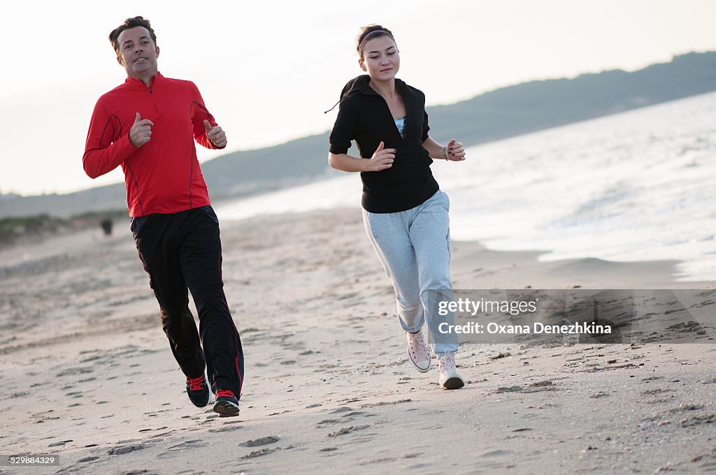 A couple jogging on the sunset beach
