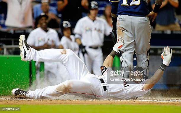 Derek Dietrich of the Miami Marlins scores following his seventh-inning triple against the Milwaukee Brewers at Marlins Park on May 9, 2016 in Miami,...