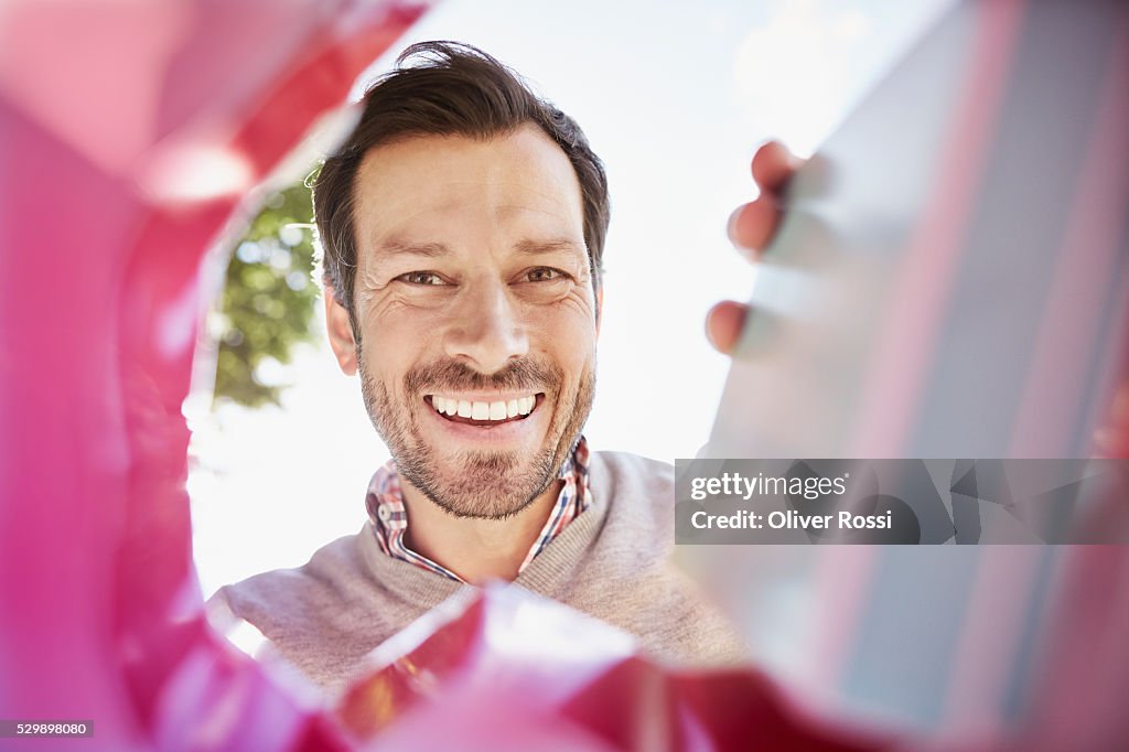 Smiling man looking into shopping bag