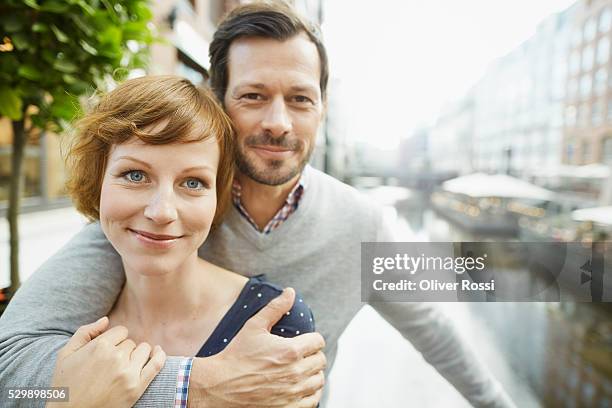 portrait of couple hugging outdoors - 30 40 woman stock-fotos und bilder