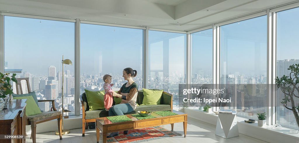 Mother and child in high rise apartment with view