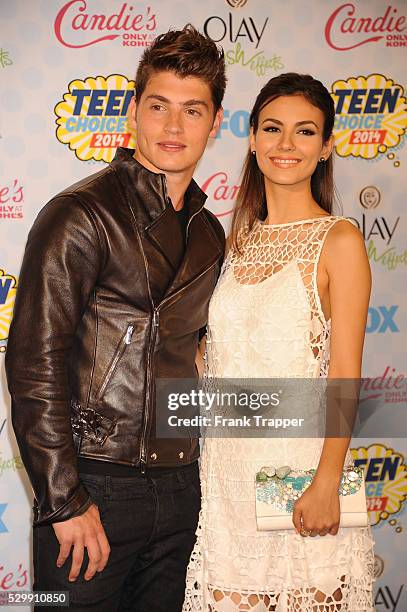 Actors Gregg Sulkin and Victoria Justice pose in the press room at the 2014 Teen Choice Awards held at the Shrine Auditorium.