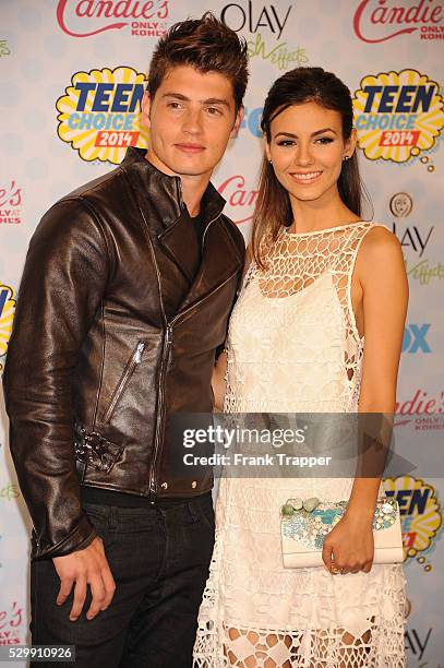 Actors Gregg Sulkin and Victoria Justice pose in the press room at the 2014 Teen Choice Awards held at the Shrine Auditorium.