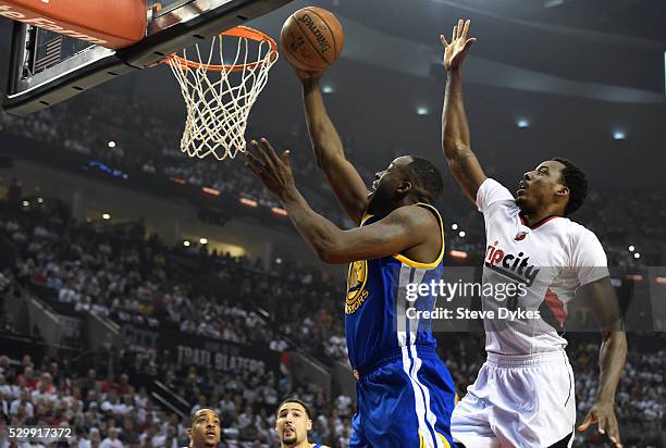 Draymond Green of the Golden State Warriors drive to the basket on Al-Farouq Aminu of the Portland Trail Blazers during the first quarter of Game...