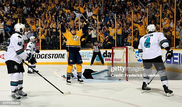 Joel Ward and Brenden Dillon of the San Jose Sharks watch as Colin Wilson of the Nashville Predators holds his hands up in celebration after scoring...