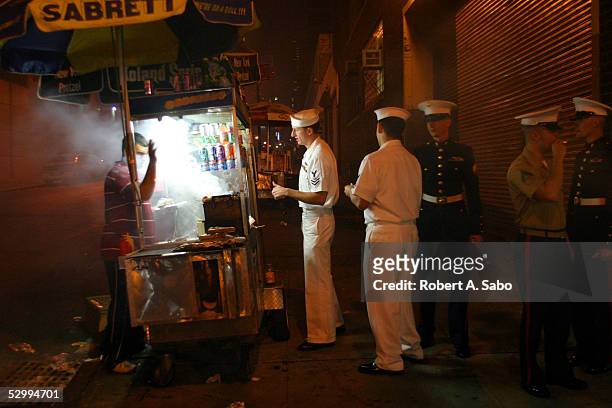 Making a last stop across the street from the piers near the USS Intrepid, Sailors and Marines wait in line for hot dogs before heading back to their...