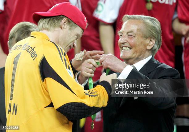 President Gerhard Mayer-Vorfelder presents a medal to Oliver Kahn of Bayern after they won the German Football Federations Cup Final between FC...