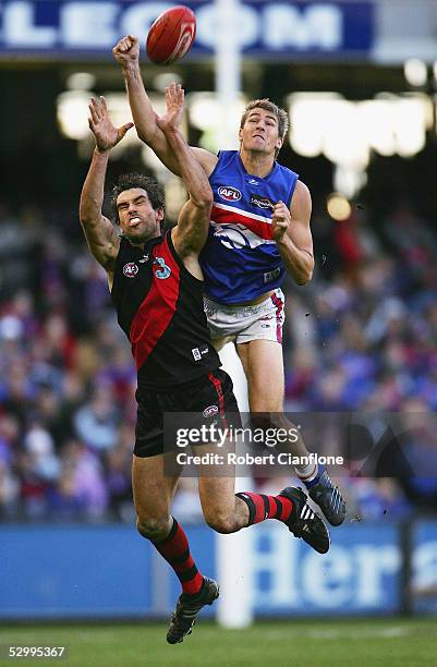 Scott Lucas of the Bombers is challenged by Adam Morgan of the Bulldogs during the round 10 AFL match between the Essendon Bombers and the Western...