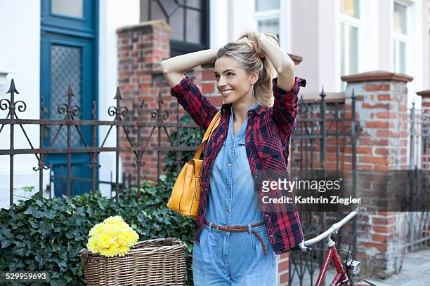 smiling woman on the street with her bicycle - plaid shirt stock pictures, royalty-free photos & images