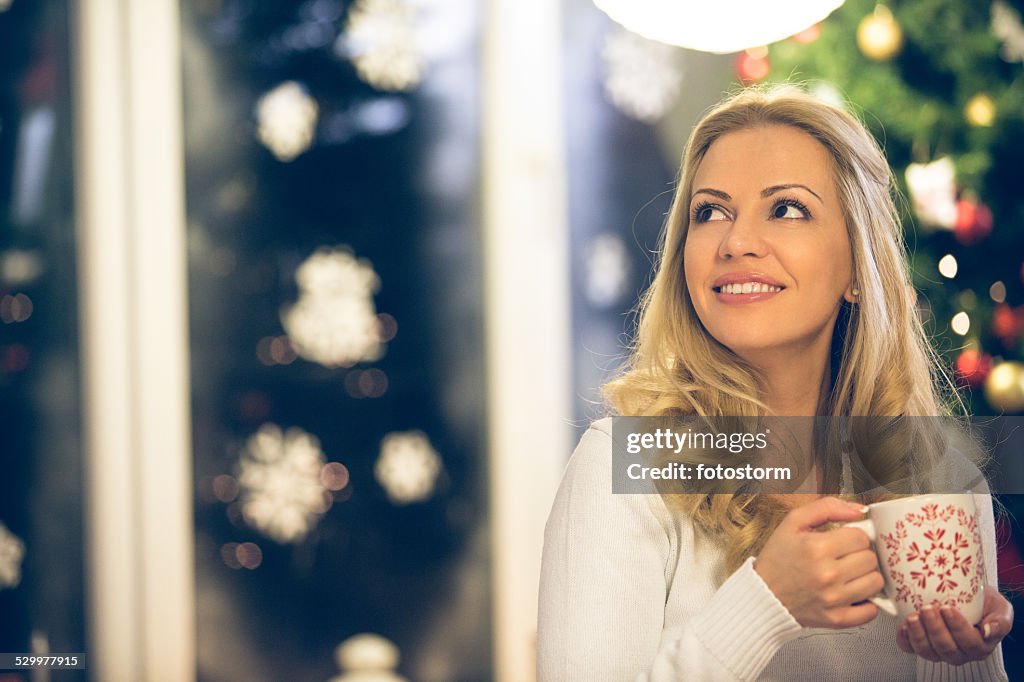 Woman drinking hot drink on Christmas eve