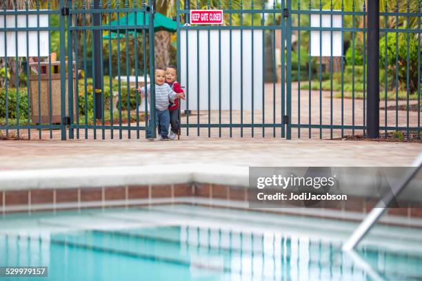 twin little boys try to enter an unlocked swimming pool - open day 3 stock pictures, royalty-free photos & images