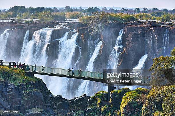 tourists crossing the knife edge bridge - zimbabwe stock pictures, royalty-free photos & images