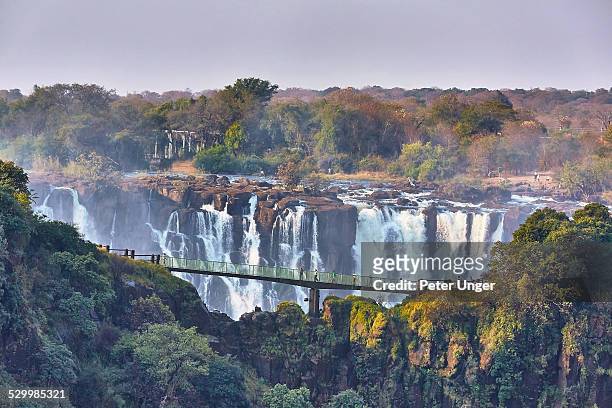 tourists crossing the knife edge bridge - zimbabwe stockfoto's en -beelden