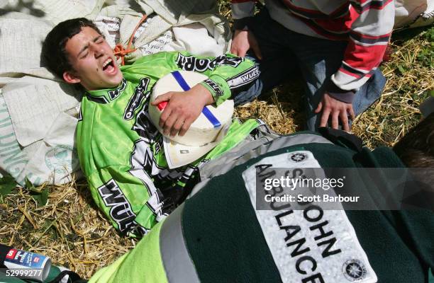 Chris Anderson, the winner of the second race holds the cheese while being tended to by medical staff after hurling himself down a steep slope in...