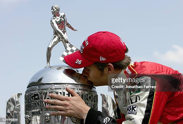 Dan Wheldon driver of the Andretti Green Racing Jim Beam Klein Tools Dallara Honda kisses the Borg-Warner Trophy on the "Yard of Bricks" a day after...