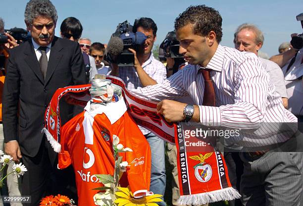 Accompanied by his chairman Luis Felipe Viera, captain of champion football team Portuguese Benfica Simao Sabrosa puts a team-scarf on the grave of...