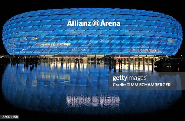 The illuminated new Allianz Arena Football stadium in Munich is reflected in the wet road 30 May 2005 after a friendly football match between TSV...