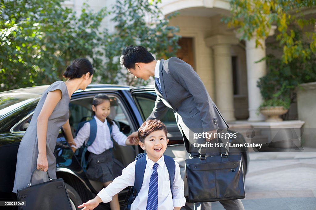 Young couple bringing their children back from school