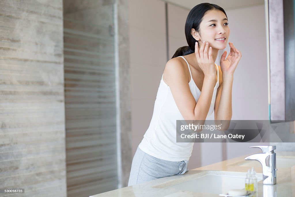 Young woman applying moisturizer